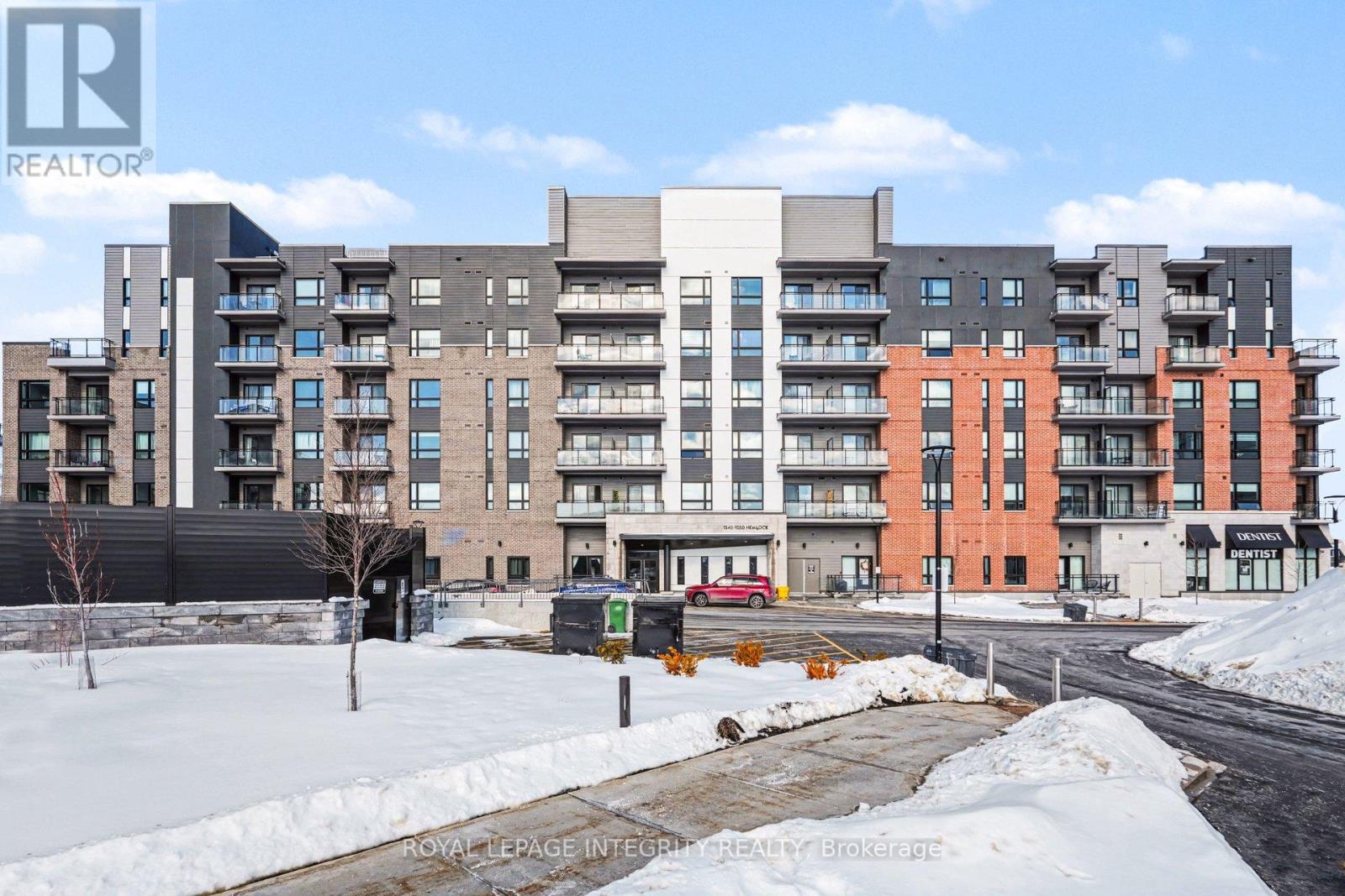 A large apartment complex with a parking lot in front.