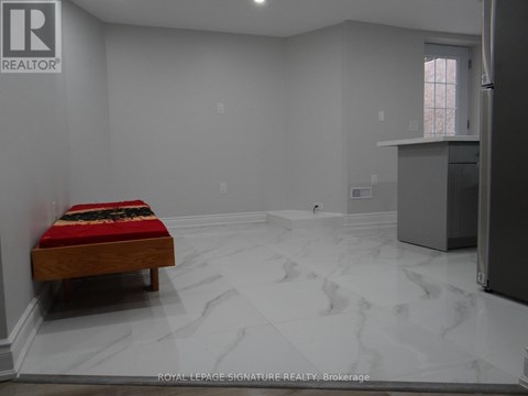 A bedroom with a bed and a refrigerator in it.