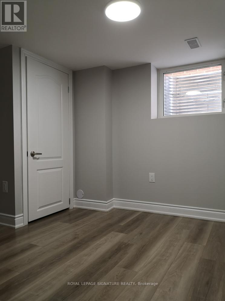 A room with a white door and wooden flooring.