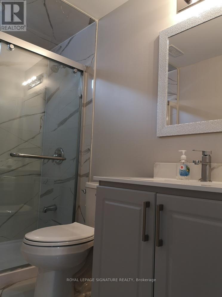 A white toilet in a bathroom with a glass shower door.