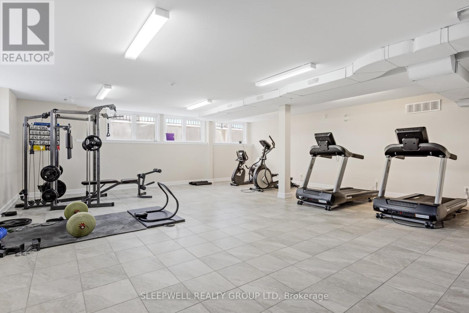 A gym with a variety of equipment including treadmills, weights, and exercise bikes.