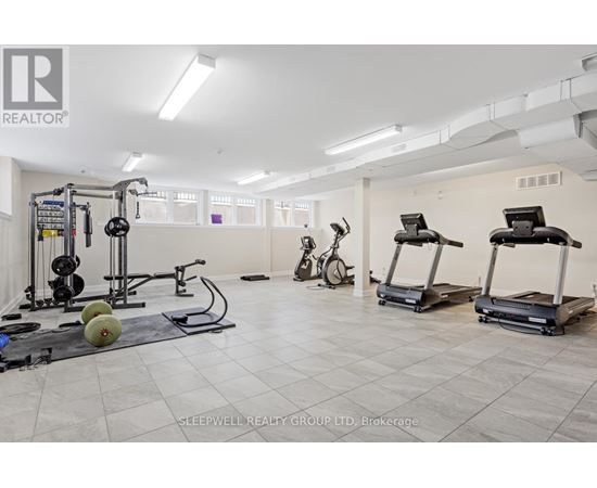 A gym with a variety of equipment including treadmills, weights, and exercise bikes.