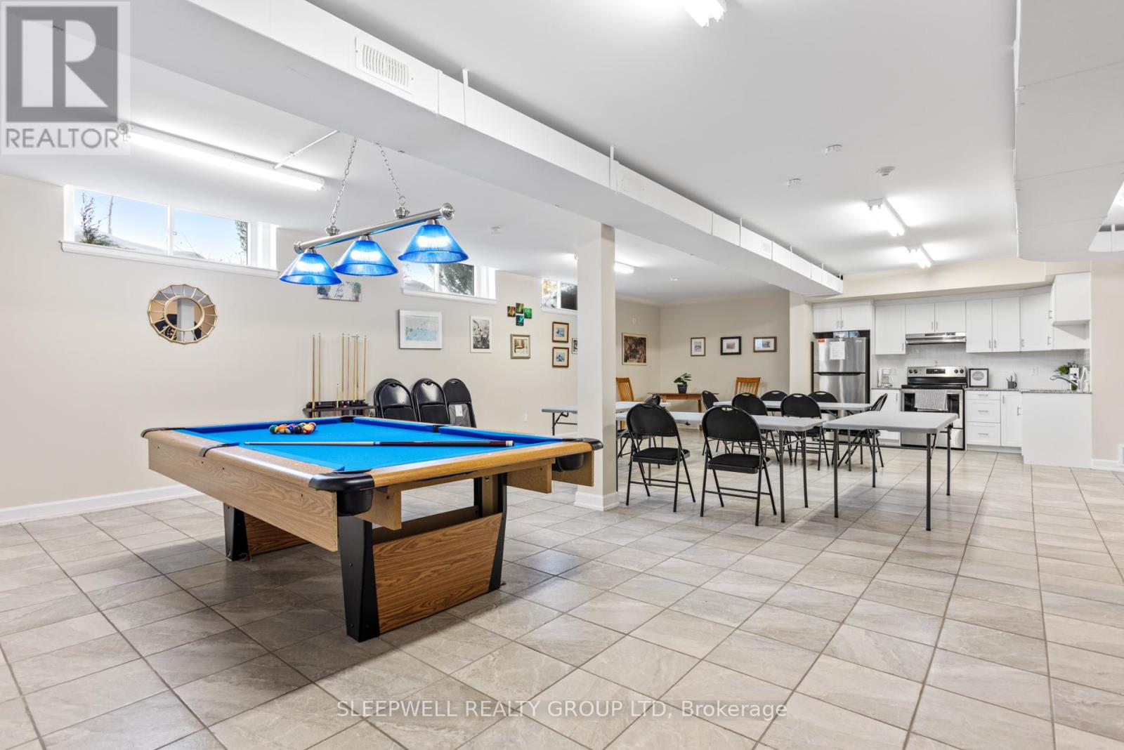 A pool table is in the middle of a room with a dining table and chairs.
