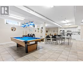 A pool table is in the middle of a room with a dining table and chairs.