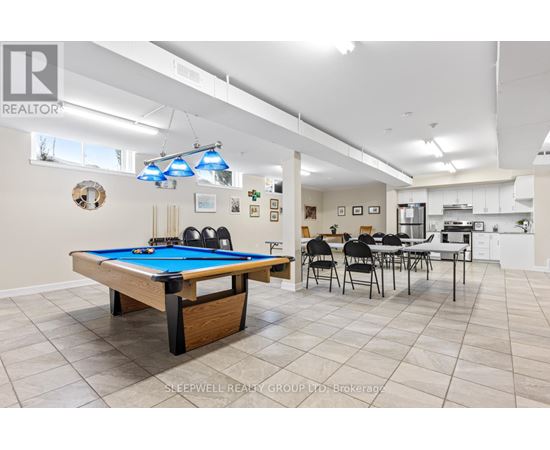 A pool table is in the middle of a room with a dining table and chairs.