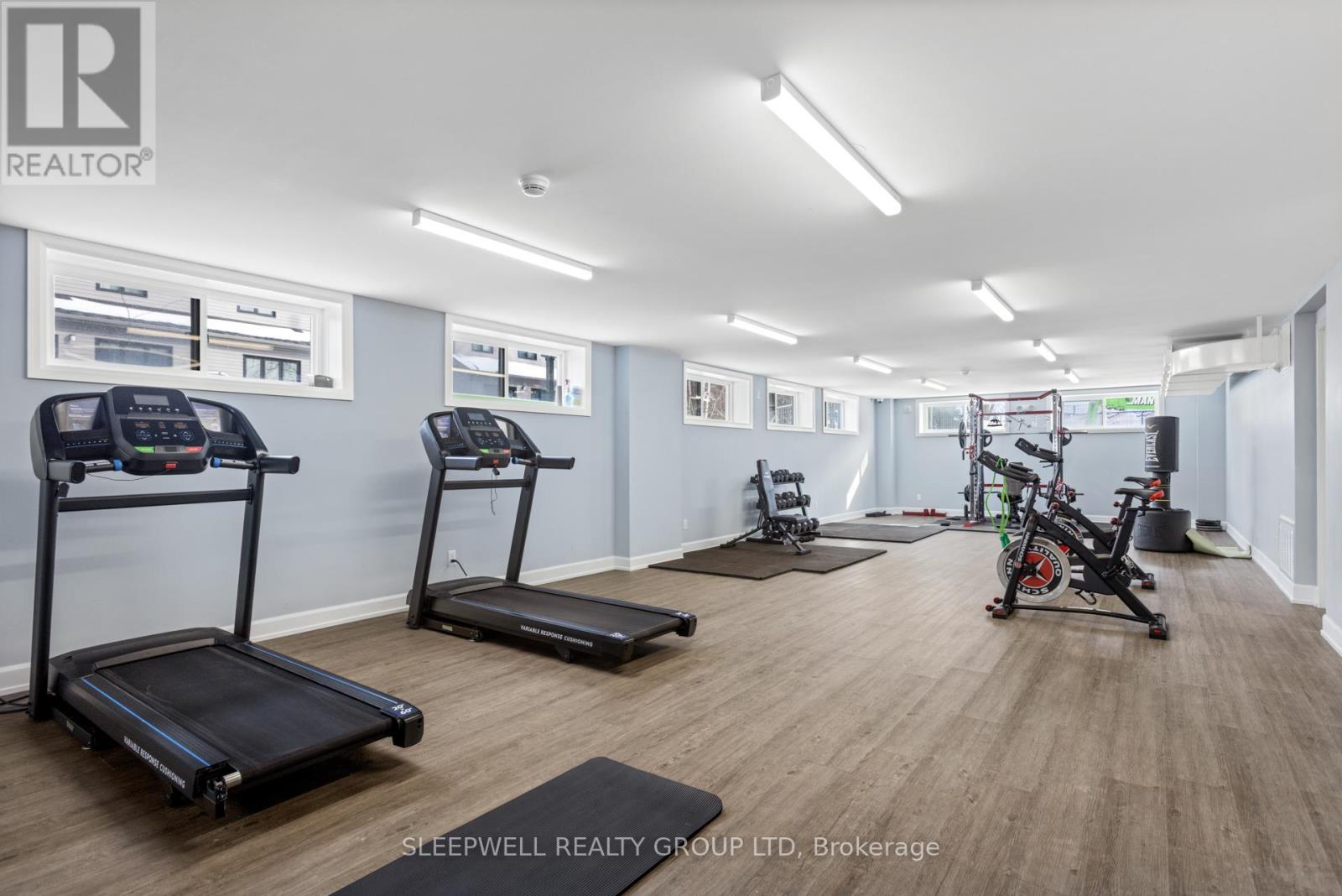 A gym with treadmills, exercise bikes, and weights.