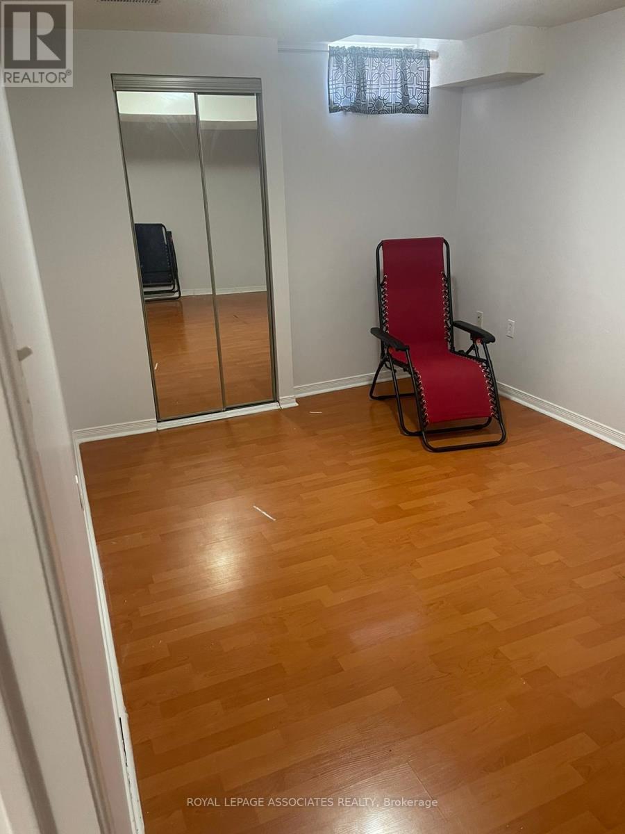 A room with a wooden floor and a red chair.