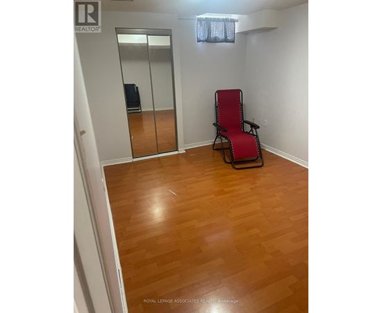 A room with a wooden floor and a red chair.
