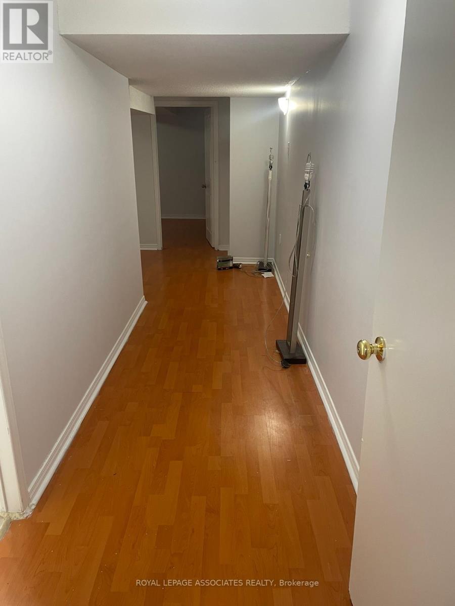 A hallway with a wooden floor and white walls.