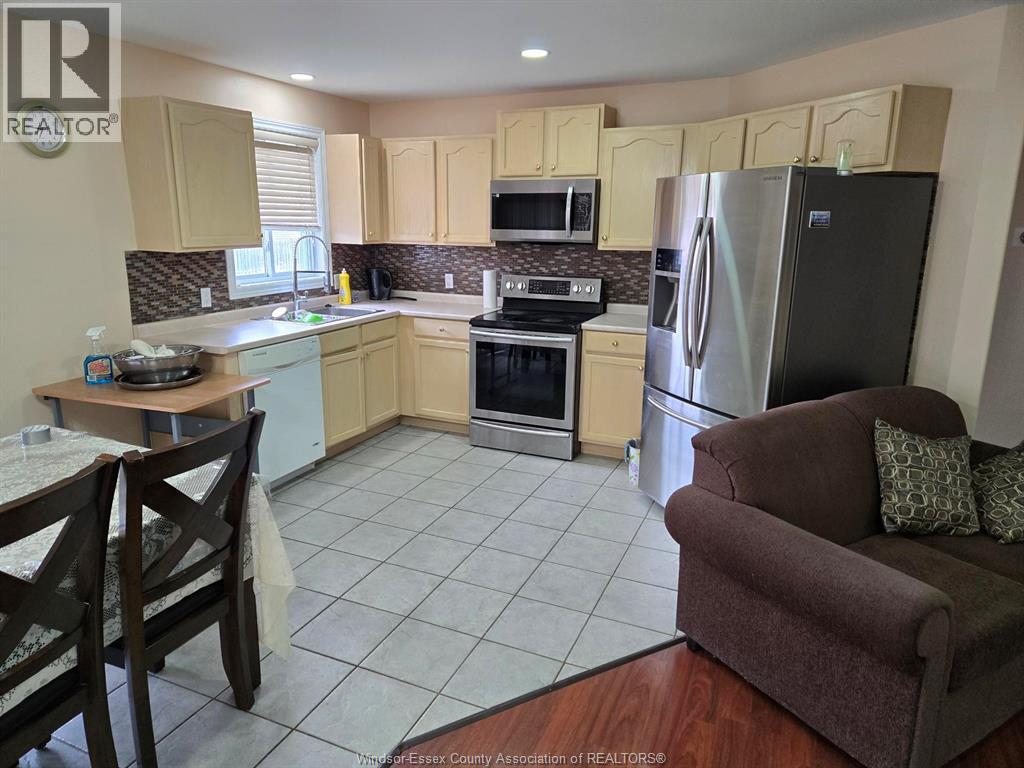 A kitchen with a refrigerator, oven, and sink.