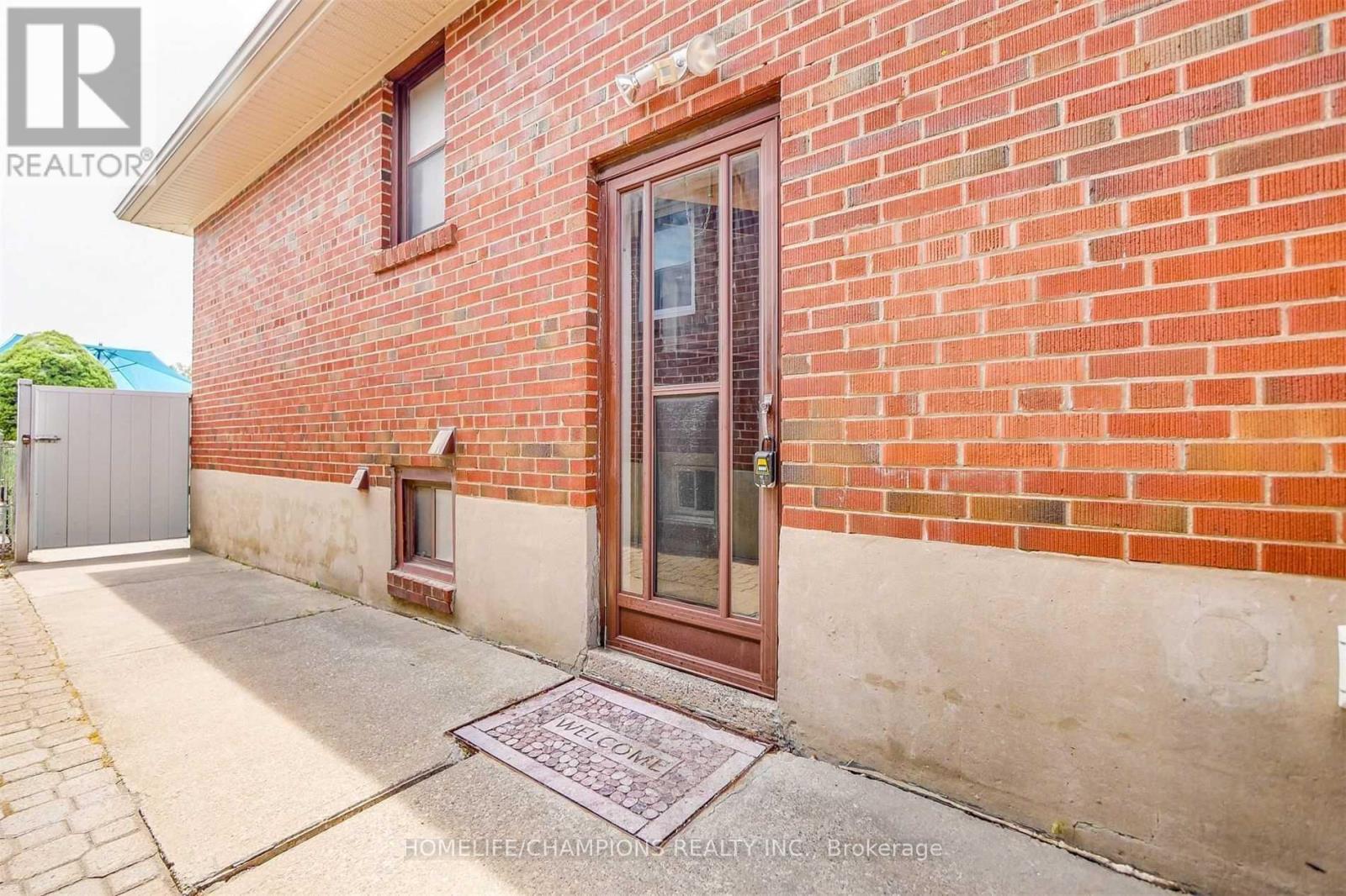 A red brick house with a brown door and a small window above the door.