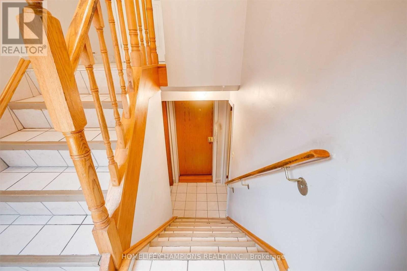A wooden staircase with a tiled floor.