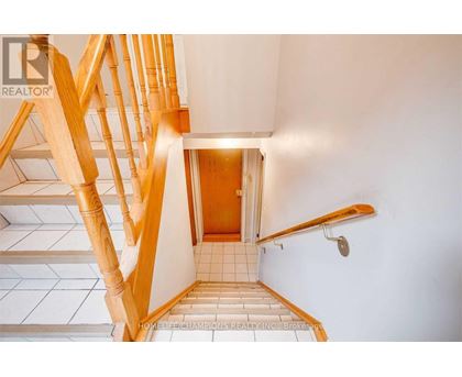 A wooden staircase with a tiled floor.