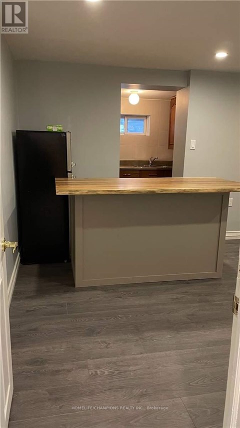 A kitchen with a black refrigerator and a wooden counter.