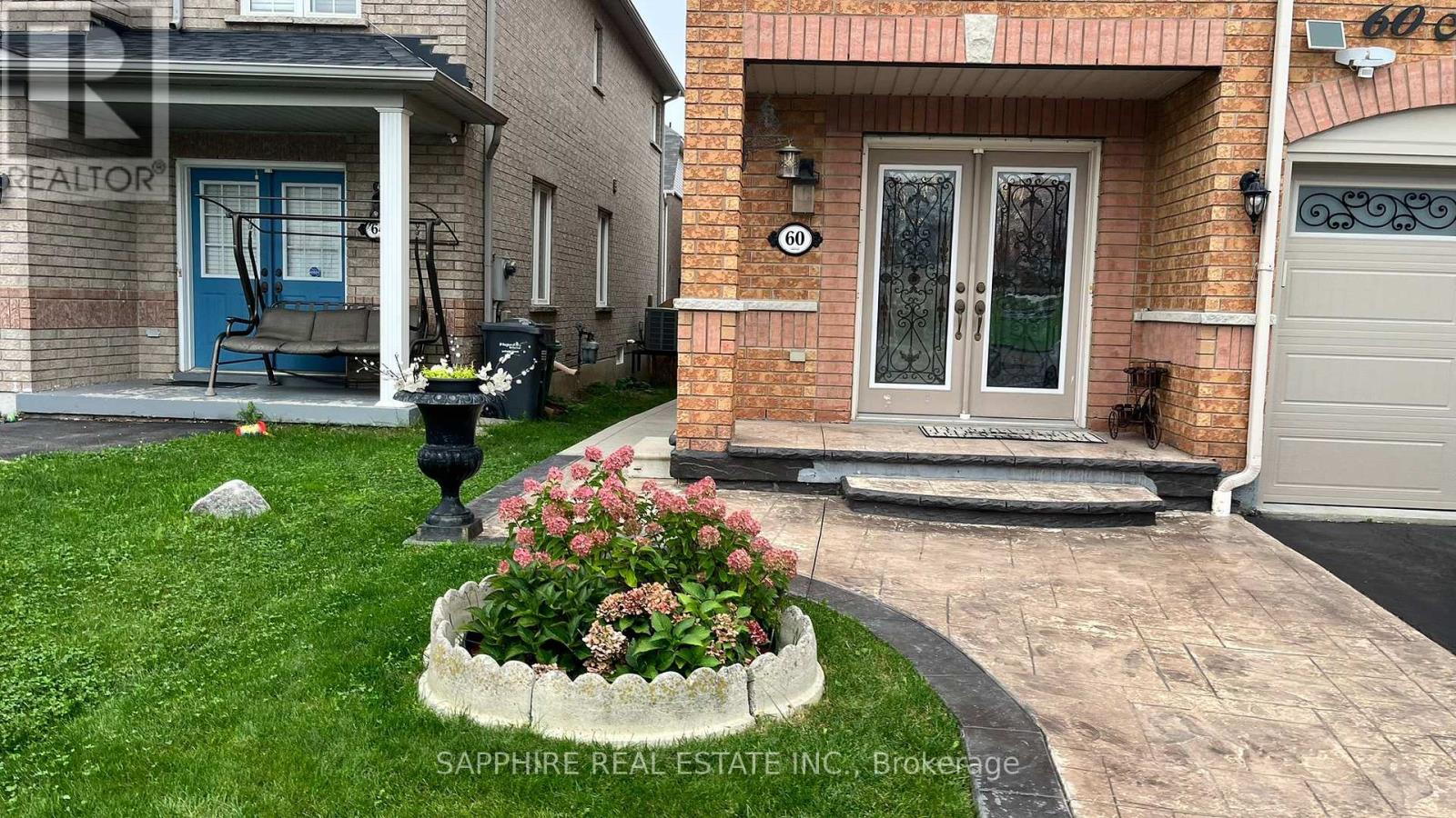 A house with a blue door and a flower bed in front.