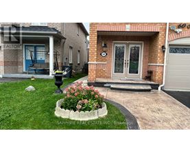 A house with a blue door and a flower bed in front.
