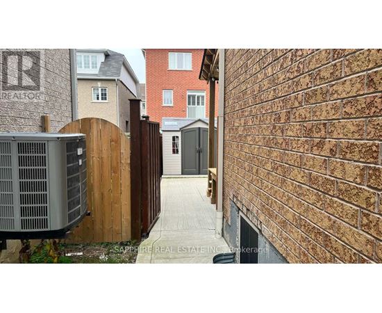 A narrow alley with a brick wall on one side and a wooden fence on the other.