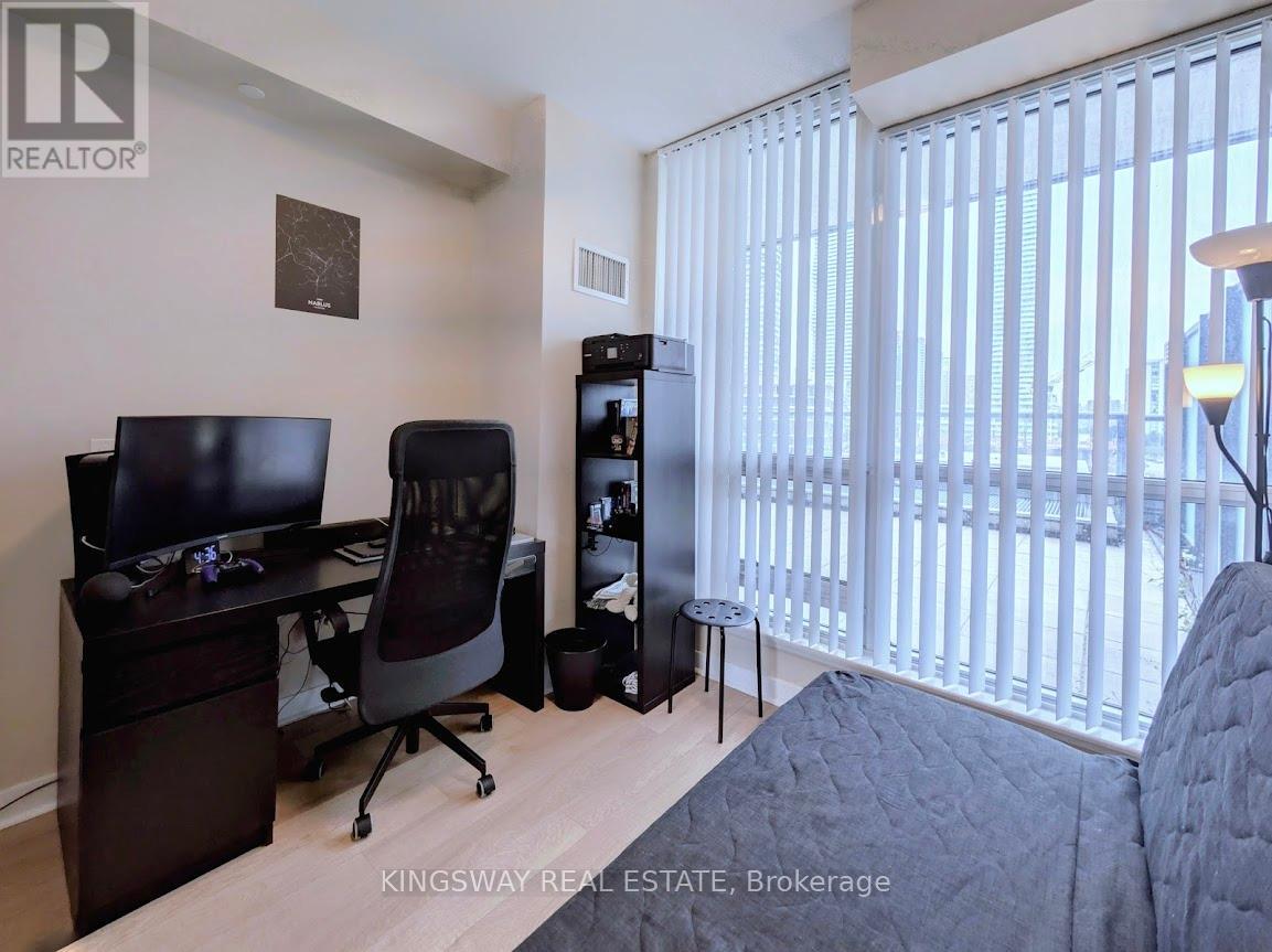 A bedroom with a desk and a chair.
