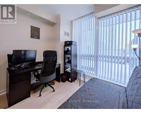 A bedroom with a desk and a chair.