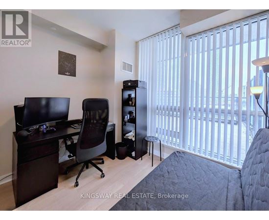 A bedroom with a desk and a chair.