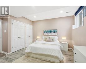A bedroom with a large bed and a painting on the wall.