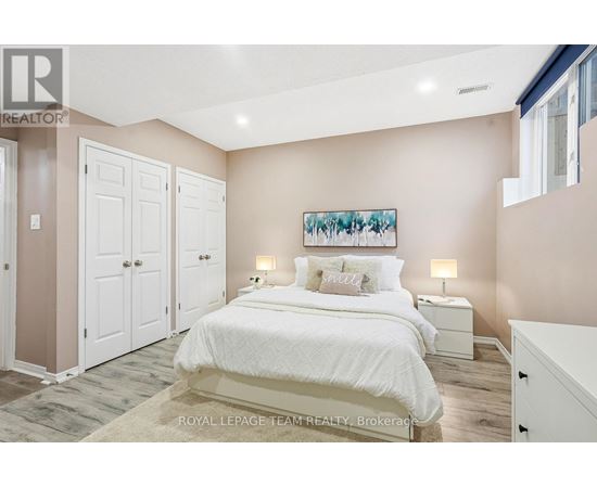 A bedroom with a large bed and a painting on the wall.