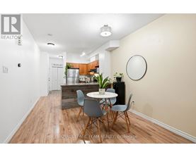 A dining area with a table and chairs in a room with wooden flooring.