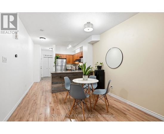A dining area with a table and chairs in a room with wooden flooring.
