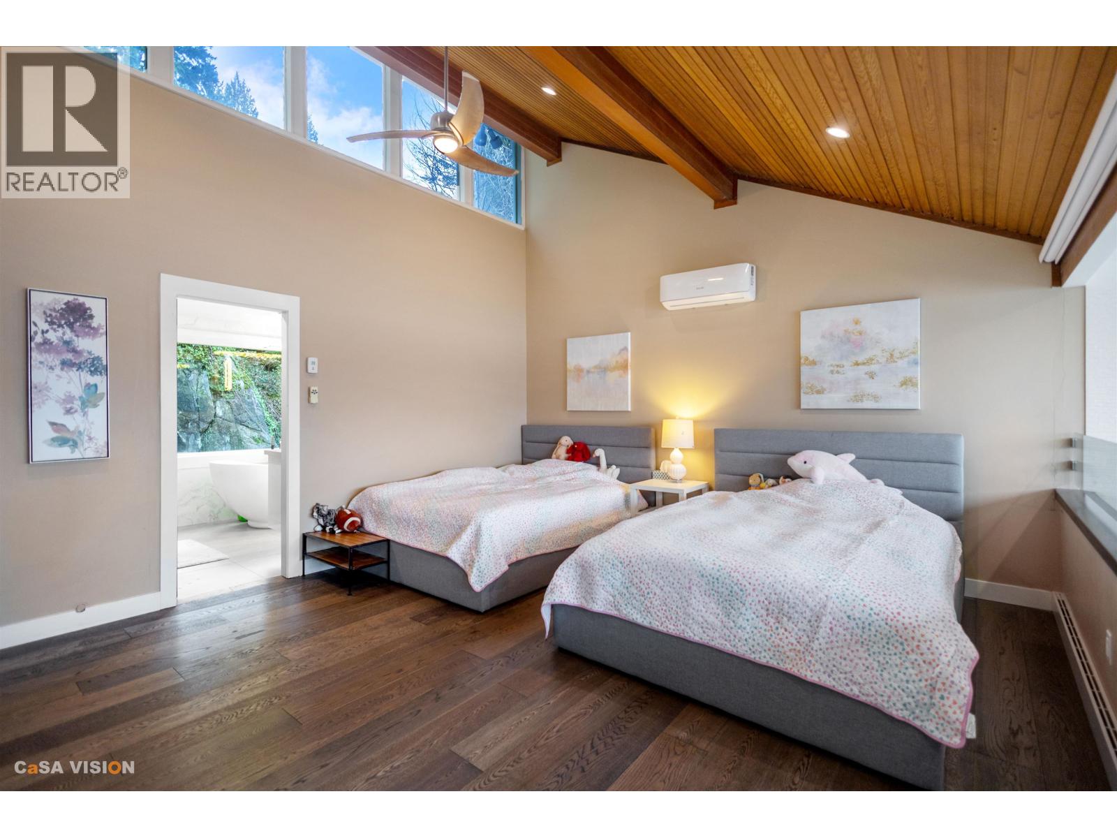 A bedroom with two beds and a window.