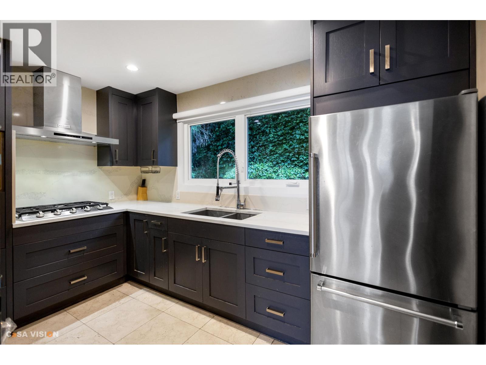 A modern kitchen with a stainless steel refrigerator.