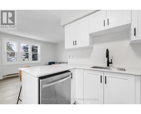 A white kitchen with a sink and cabinets.