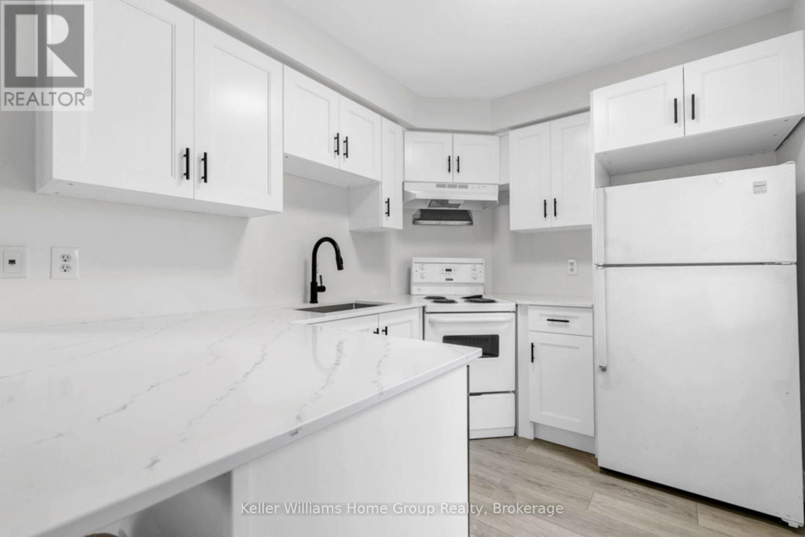 A white kitchen with a counter top and cabinets.