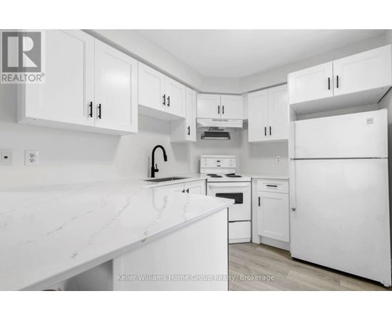 A white kitchen with a counter top and cabinets.