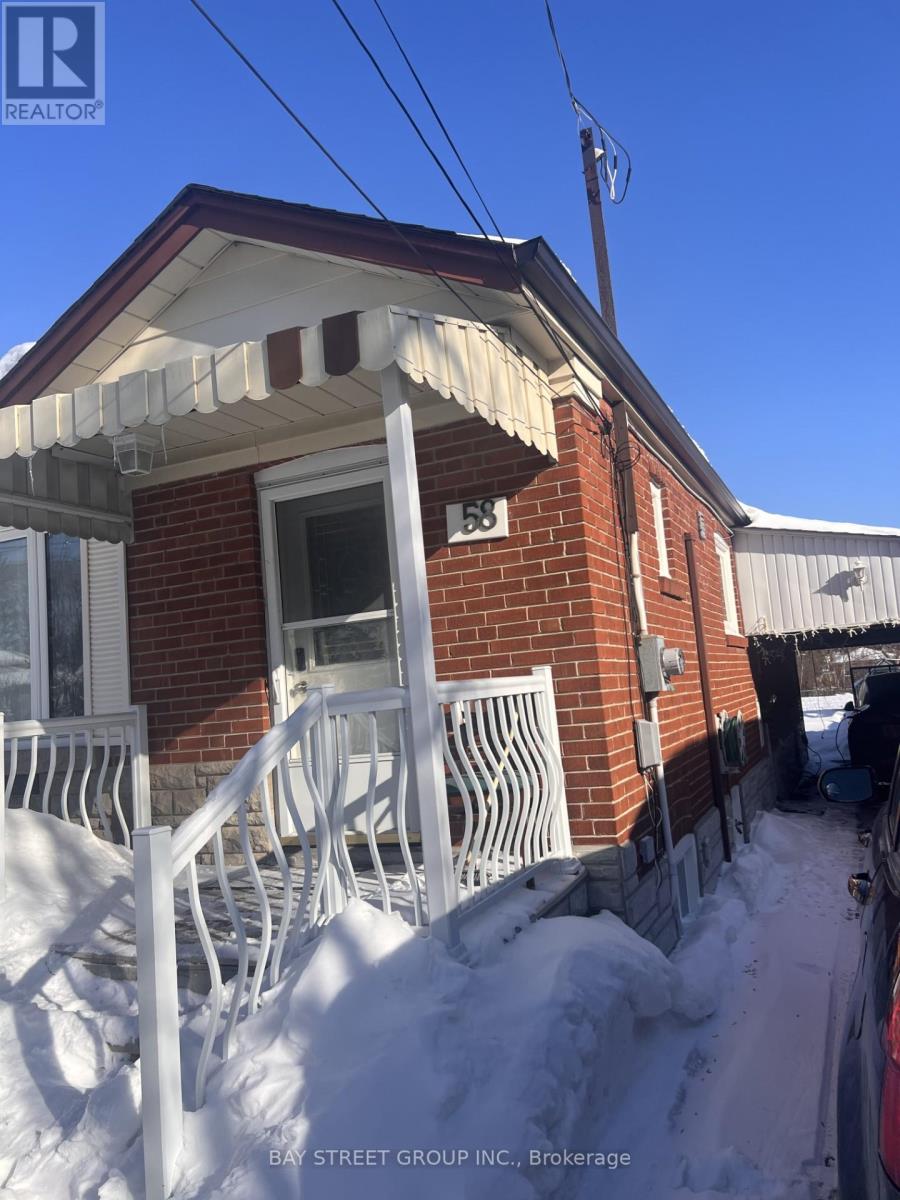A red brick house with a white porch and snow on the ground.