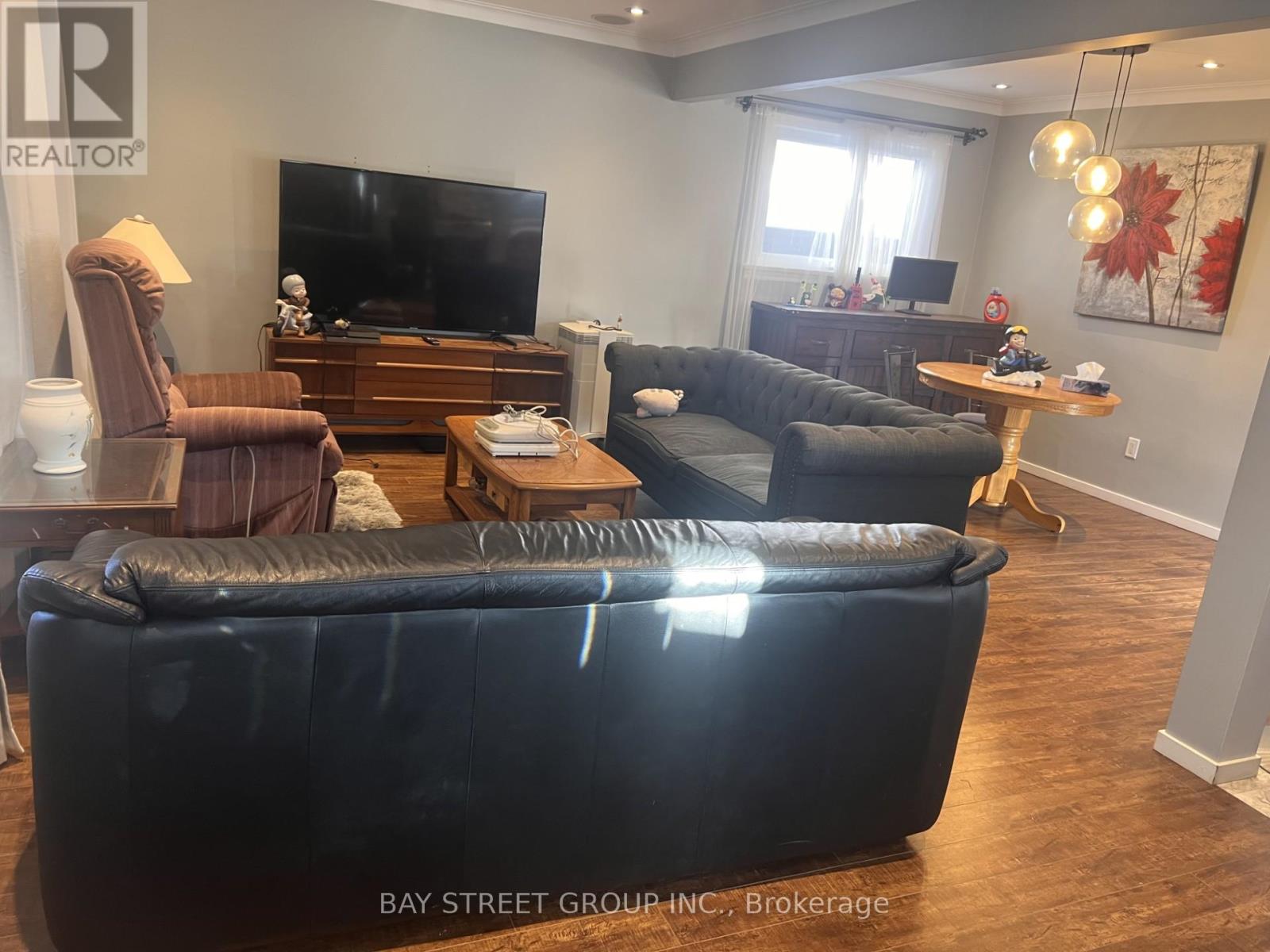 A living room with a black couch and a television.