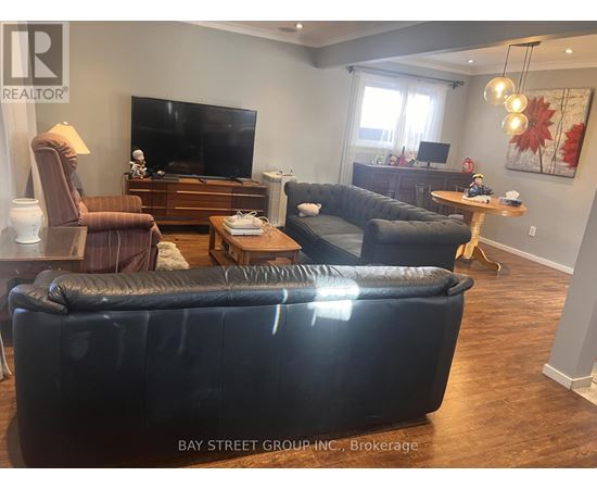 A living room with a black couch and a television.