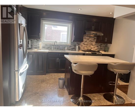 A modern kitchen with dark wood cabinets and a stainless steel refrigerator.