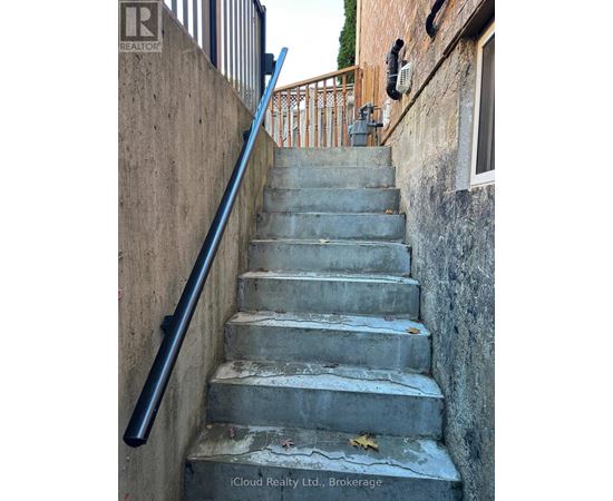 A concrete staircase with a metal handrail.