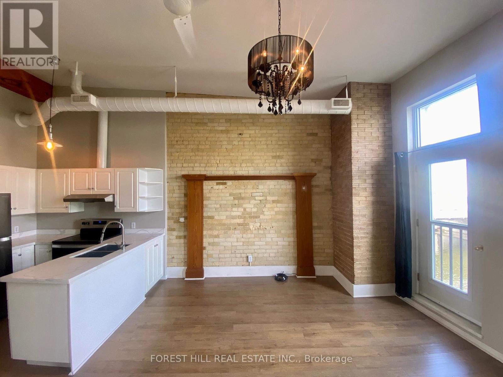 A kitchen with white cabinets and a brick wall.