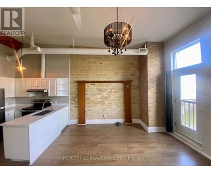 A kitchen with white cabinets and a brick wall.