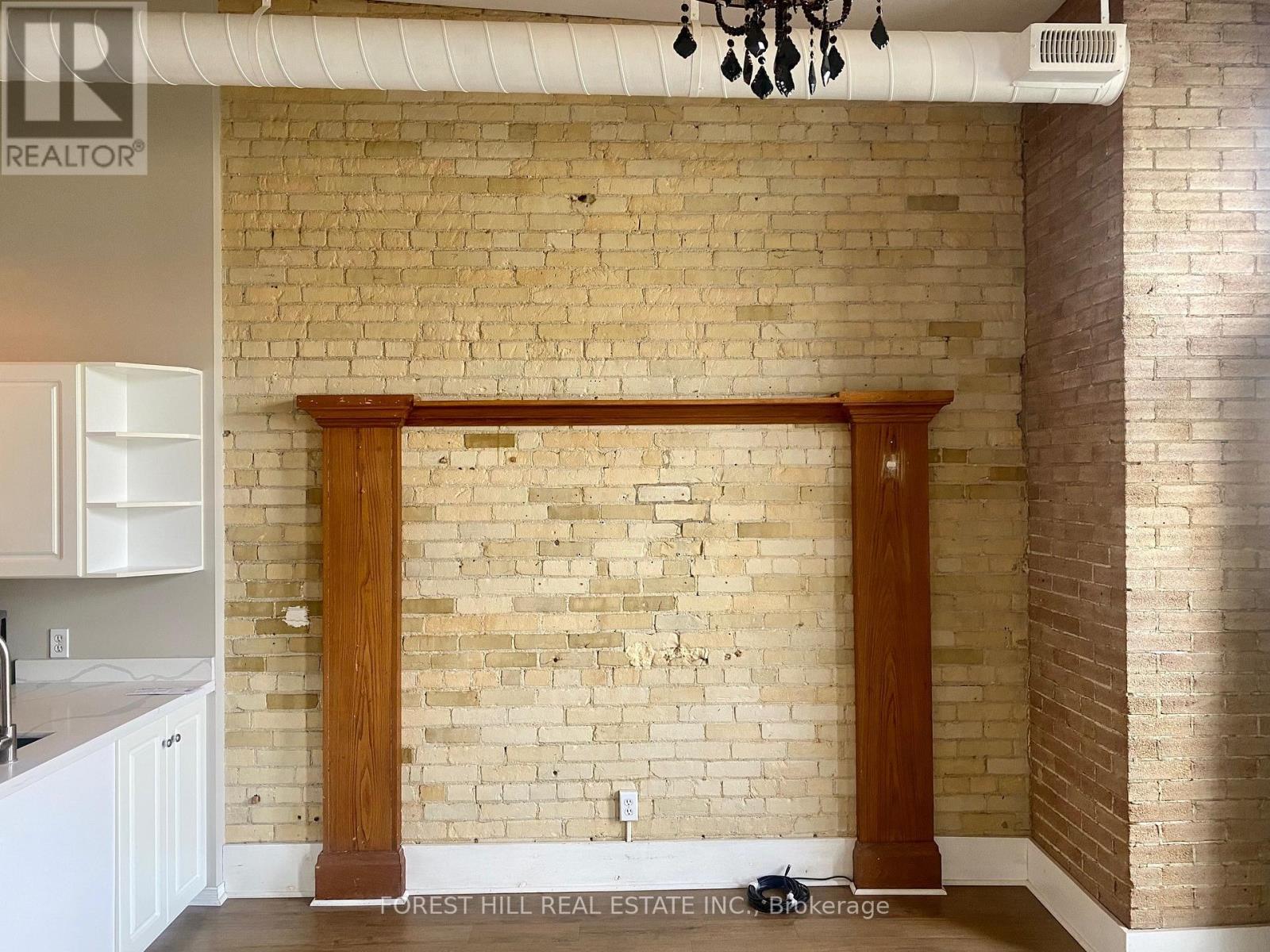 A kitchen with a brick wall and wooden columns.