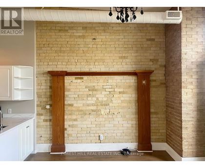 A kitchen with a brick wall and wooden columns.