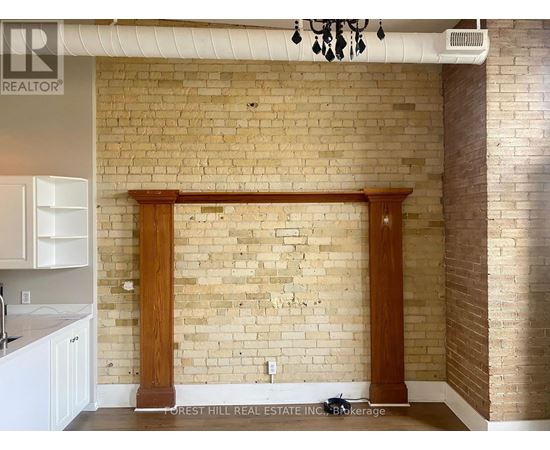 A kitchen with a brick wall and wooden columns.
