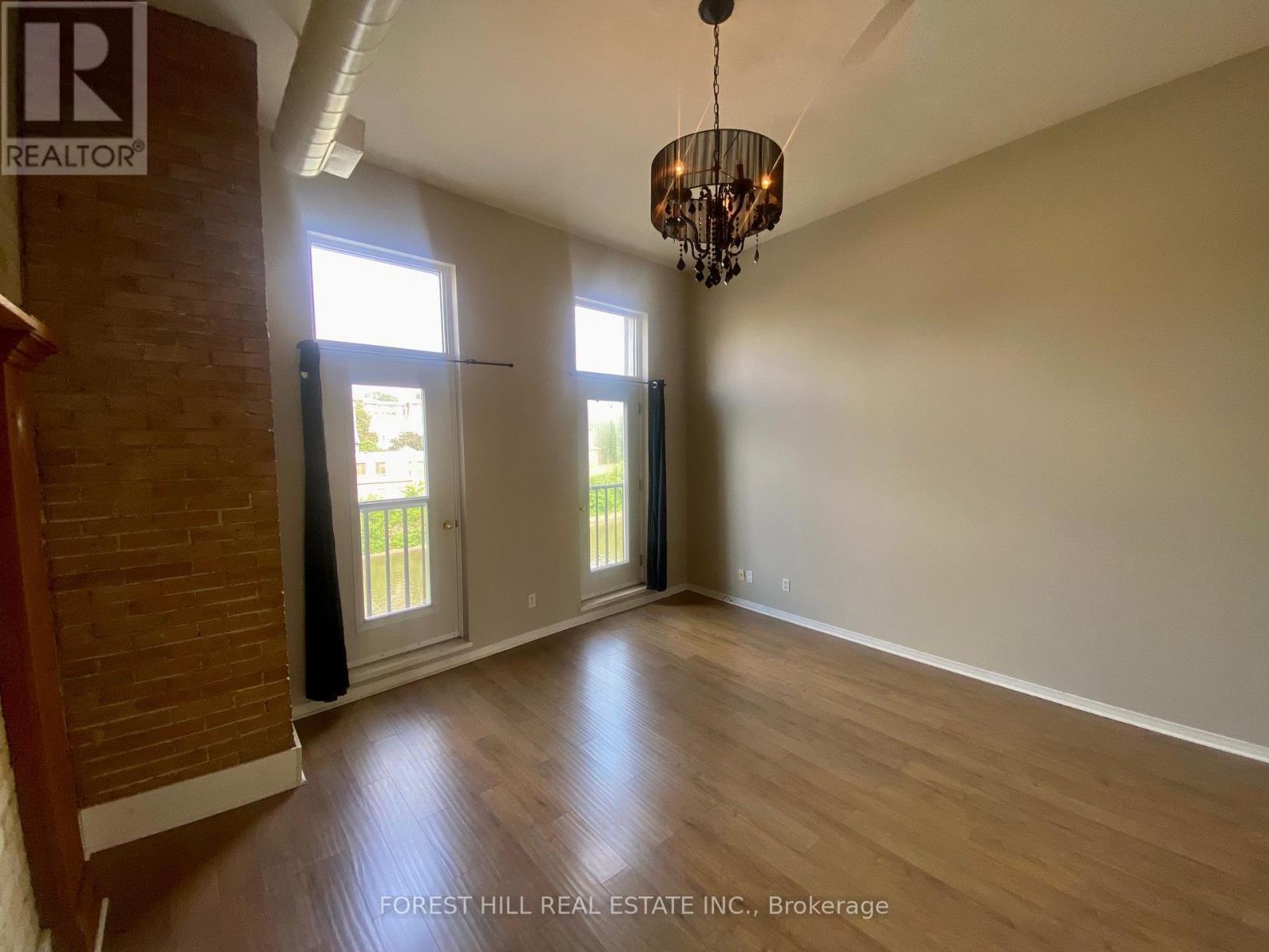 A room with wooden floors and a chandelier hanging from the ceiling.