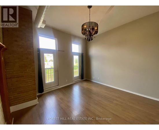 A room with wooden floors and a chandelier hanging from the ceiling.