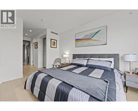 A bedroom with a large bed and a painting on the wall.