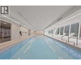 A large indoor swimming pool with a diving board.