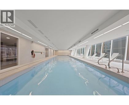 A large indoor swimming pool with a diving board.