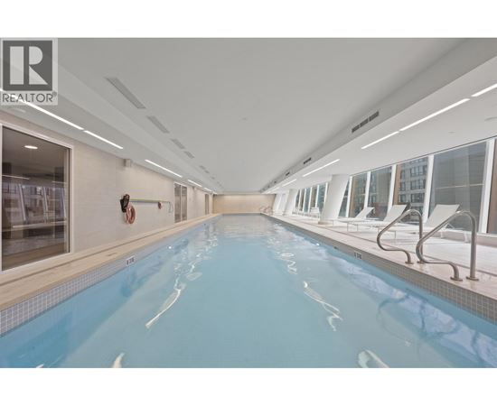A large indoor swimming pool with a diving board.
