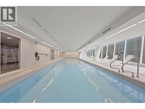A large indoor swimming pool with a diving board.
